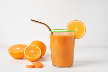 Glass of healthy smoothie and ingredients on white wooden background