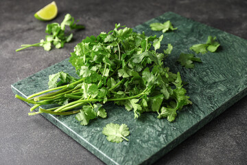 Board with fresh cilantro on dark background