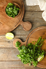 Boards with fresh cilantro and lime on wooden background