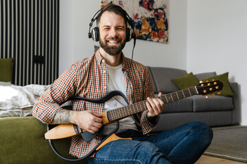 Obraz premium Smiling mid aged brunette bearded man playing