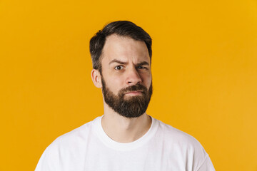 Obraz premium Portrait of a confused brunette bearded man standing