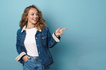 Blonde happy woman smiling and pointing finger aside