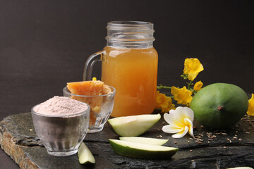 Raw Mango juice - Aam Panna or Panha in a transparent glass with whole green fruit,