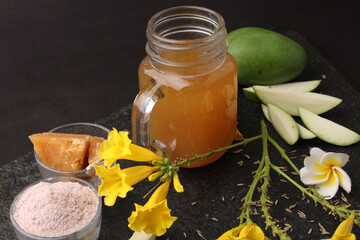 Raw Mango juice - Aam Panna or Panha in a transparent glass with whole green fruit,