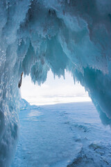 Winter Baikal. The fantastic beauty of the grottoes, framed by numerous transparent icicles. Natural winter background