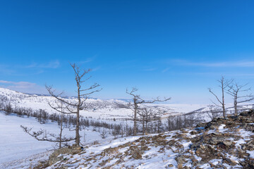 Olkhon island winter landscape. View of the mountains, frozen Lake Baikal and the federal highway Irkutsk-Khuzhir on a cloudy day
