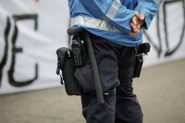 Details with the riot kit of a Romanian jandarm during a rally: gun, helmet, radio station, baton.