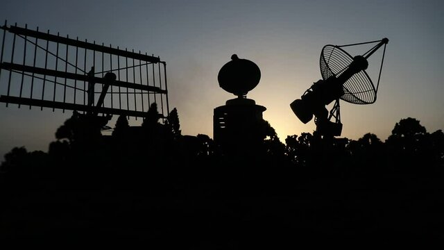 Space radar antenna on sunset. Silhouettes of satellite dishes or radio antennas against night sky. Creative artwork decoration. Selective focus