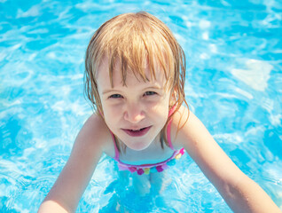Fototapeta na wymiar Smiling child with in swimming pool