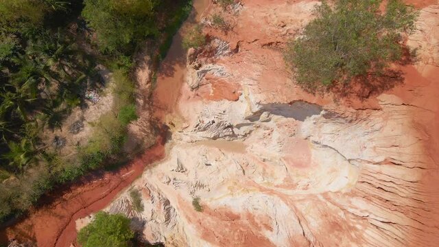 Aerial slowmotion shot of a red canyon or Fairy stream at the border of desert in the Mui Ne village in southern Vietnam
