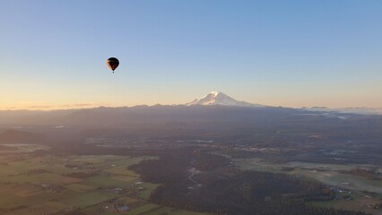Hot air balloon at dawn with snowy mountain on the background