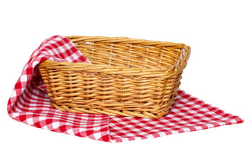 Empty picnic basket. Close-up of a empty wicker basket on a red white checkered napkin, blanket or tablecloth isolated on a white background. For your food and product display montage. Macro.
