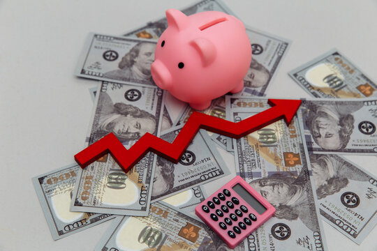 Piggy bank and arrow up on dollar banknotes
