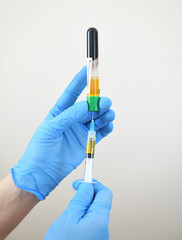  Plasma lifting - close-up of a doctor's hand in blue rubber gloves with a syringe. Plasmolifting...