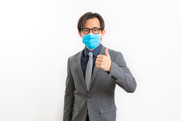 Portrait of a middle-aged Asian businessman wearing a blue face mask on white background. Covid19, Health, and Business Concepts.