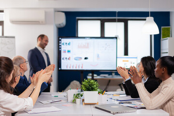 Succesful business man presenting the good evolution of company using digital device. Diverse multiethnic colleagues with new opportunity enjoing victory meeting in broadroom office.