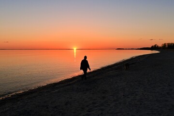 silhouette of a person walking on the beach