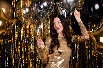 Photo of optimistic brunette lady hold glass balloon wear nice dresses isolated on bright gold color background