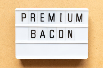 Lightbox with word premium bacon on wood background
