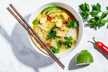 Thai green curry chicken soup with rice noodles, chili and herb in white bowl. - obrazy, fototapety, plakaty