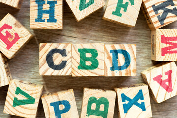 Alphabet letter block in word CBD (Abbreviation of Central business district or .Cannabidiol) with another on wood background