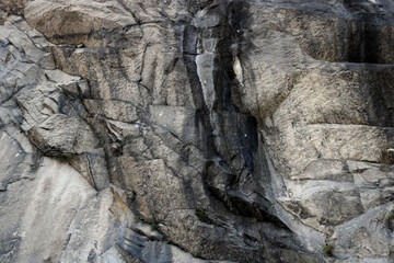 irregular gray rocky surface with black grooves furrowing its reliefs
