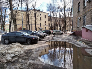 A large puddle, cars and fragments of houses