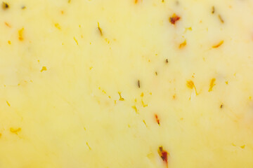 Yellow cheese with herbs and spices background Texture . Close up, macro photo.