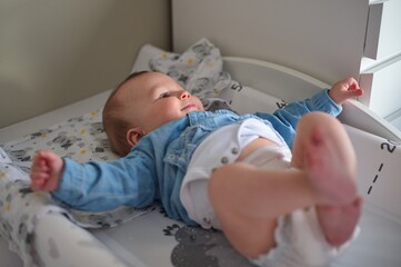 Cute little baby in diapers on the changing table