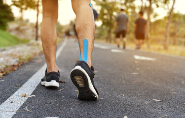 close up of young Asian sports man has pain at muscles and joints during outdoor exercise, over...