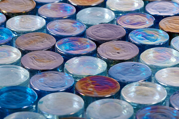 Round blue iridescent glass tiles in a row at and angle