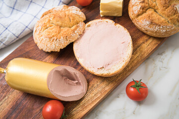 Feine Kalbsleberwurst auf Weizen Rosen Brötchen dazu Tomaten, Butter mit Holzbrett, Geschirrtuch...