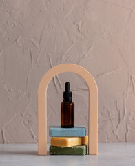 Dark bath bottle and soap on arch decorated background