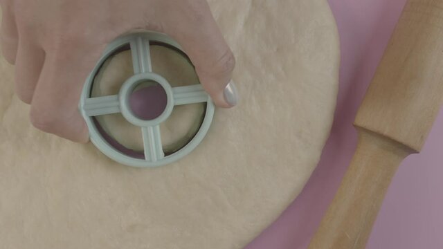 Cut out dough circle for making dounuts woman hand rolling pin baking concept