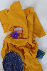 Yellow plain shirtsleeve cotton T-Shirt mockup on white  background  with Eye stone,  blue flower, dry blue leaf