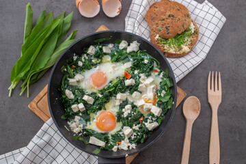 Shakshouka - Middle eastern traditional dish with poached eggs and wild garlic