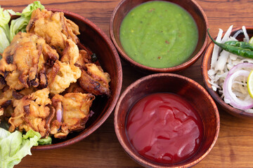 Tasty Indian Street Food With Various Names Like Onion Bhajji Pyaj Pakora Or Pakore Pyaaj Ke Pakode Or Pakoda Kanda Bhaji Pyaaz Bajji Served With Green Chutney And Ketchup Is Tea Time Chaat Snacks