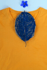 Yellow plain shirtsleeve cotton T-Shirt mockup on white  background  with   blue flower