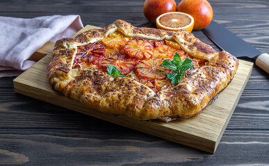 Red blood orange galette, seasonal pie with citrus. Tasty baking with honey and mint. Selective...