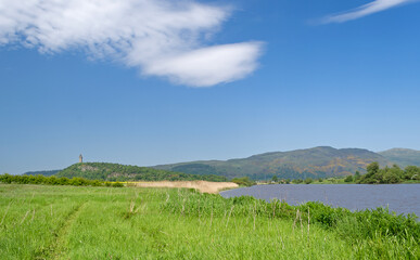 Fototapeta premium Scenic Summer view from Cambuskenneth Abbey in Stirling, Scotland of the Forth River with the Wallace Monument in the distance.