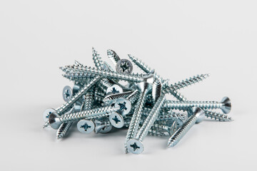 Shiny metal screws on a white background