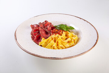 fresh pasta with cheese and meat sauce on a white plate in the studio