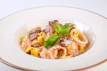 fresh pasta with seafood on a white plate in the studio