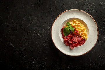 fresh pasta with cheese and meat sauce on a white plate in the studio