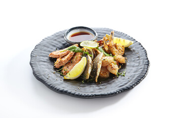 Teppanyaki Style Seafood - Grilled Mixed Seafood with Soy Sauce and Vegetables. Japanese Teppanyaki Salmon Steak, Shrimp, Scallop and Fish Fillet garnished with lemon and green salad.