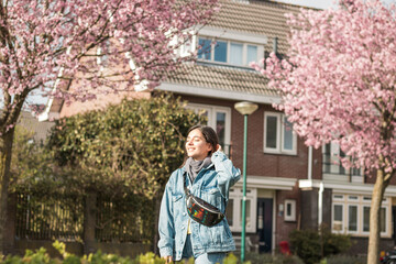 Fototapeta na wymiar young cheerful mixed races woman outdoor in front of her house taking some fresh air under sunbeams after quarantine