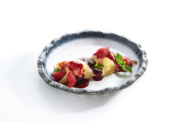 French Style Crepes - Cream Crepes with Berry and Fruit. Pancake Breakfast on white and blue plate isolated on white background. Mixed berry crepes garnished with mint and sweet sauce.