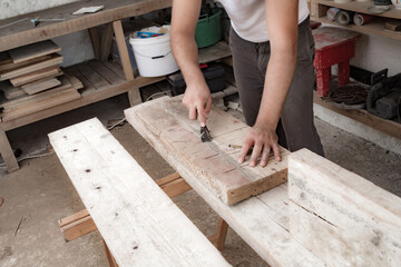 Male carpenter working with wood material in a garage.