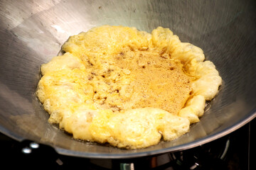 Omelet cooking in the frying pan.
