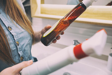 Woman reads the composition of cleaning products after buying them in the supermarket